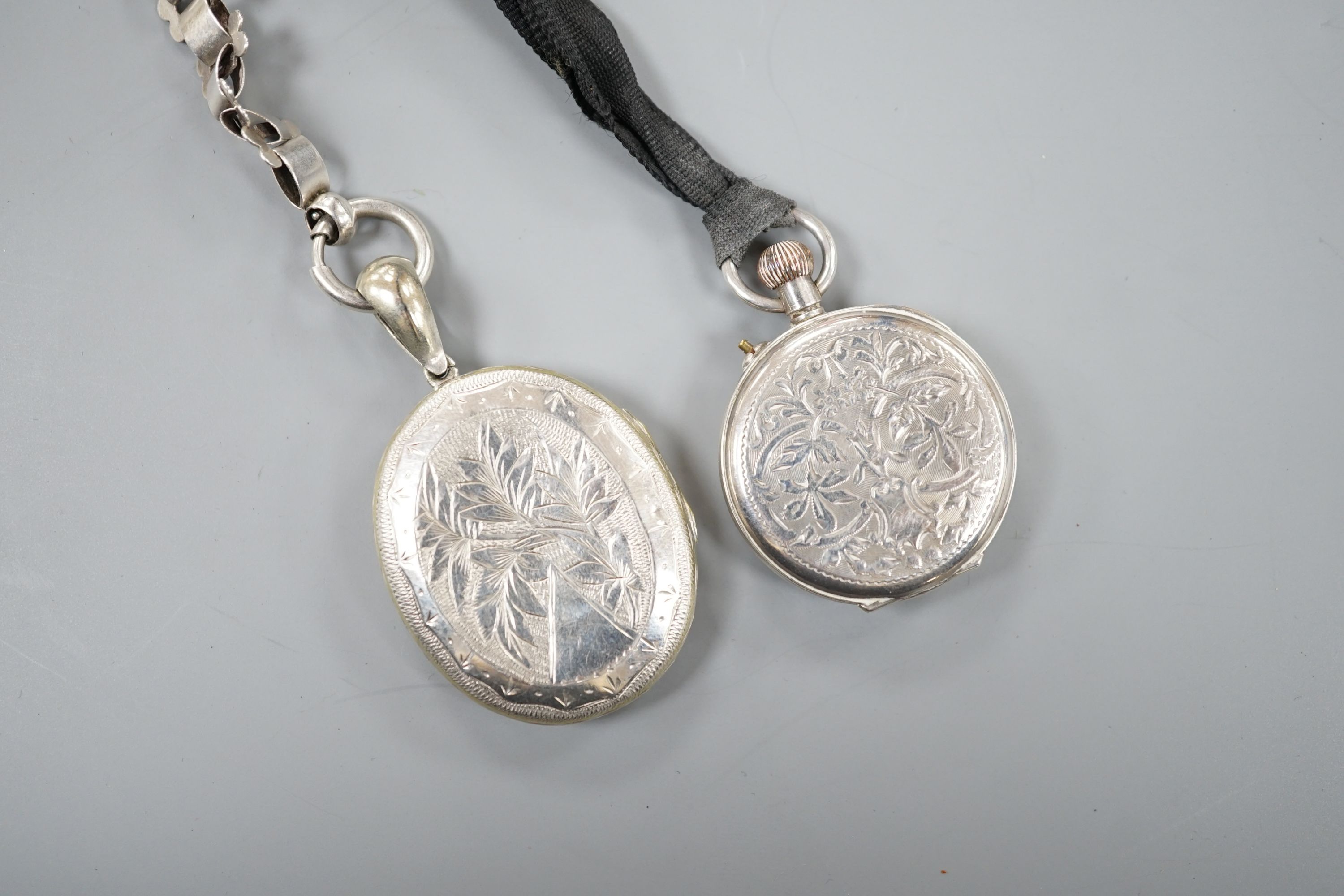 A lady's silver cased fob watch and a white metal oval locket on chain.